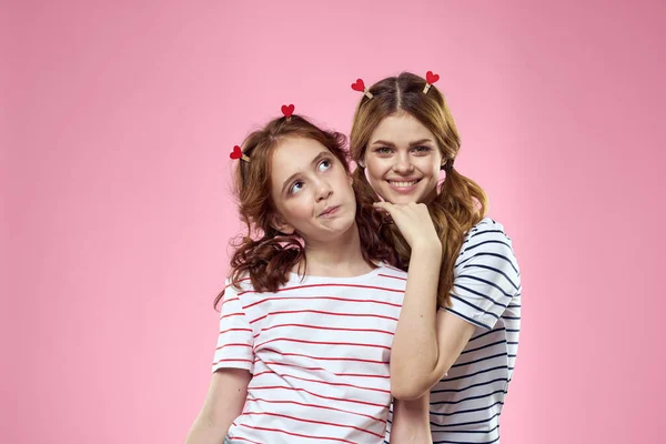 Alegre mãe e filha alegria estilo de vida estúdio rosa fundo família — Fotografia de Stock