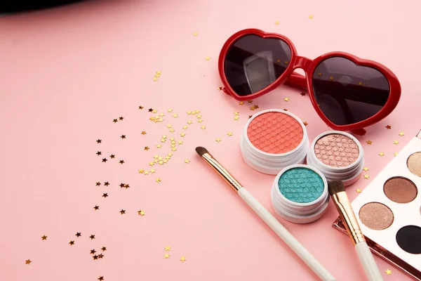 Accesorios de sombra de ojos perlas maquillaje cepillos colección cosméticos profesionales sobre fondo rosa — Foto de Stock