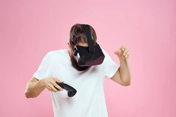 男で仮想現実メガネジョイスティック再生ビデオライフスタイルホワイトtシャツピンクの背景 — ストック写真