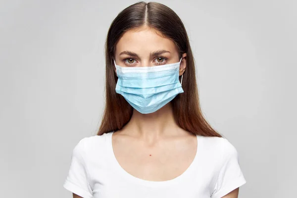 Porträtt av en kvinna Medicinsk ansiktsmask titta framåt vit t-shirt — Stockfoto