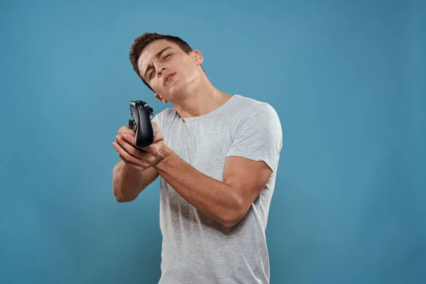 Um homem com um joystick em suas mãos entretenimento tecnologia de lazer videogames azul fundo branco t-shirt — Fotografia de Stock