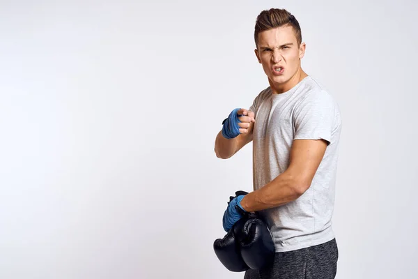 Homem forte com luvas de boxe e em uma camiseta branca em um fundo isolado vista cortada do modelo — Fotografia de Stock