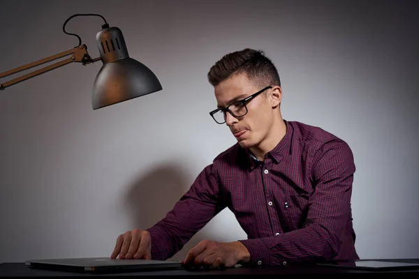 Affärsman i glasögon och en skjorta sitter vid ett bord med öppna bärbara datorer Coffee Space mobiltelefon — Stockfoto