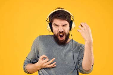 Kulaklıklı bir adam müzik, yaşam tarzı teknolojisi, sarı arka plan.