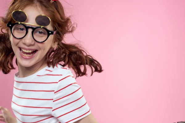 Χαριτωμένο κορίτσι γυαλιά ηλίου ριγέ t-shirt lifestyle διασκεδαστικό στυλ ροζ φόντο — Φωτογραφία Αρχείου