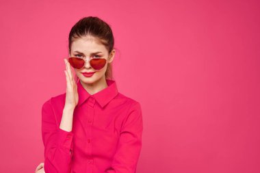 Pembe gömlekli ve kahverengi gözlüklü kadın kırpılmış görünüm modeli duyguları el hareketleriyle resim yapıyor.