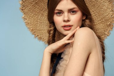 Gri arka planda hasır şapkalı romantik bir kız ve bej renkli bir elbise siyah kurdele duygu modeli.