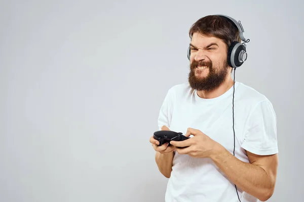 Man in hoofdtelefoon met gamepad spelen hobby entertainment lifestyle lichte achtergrond — Stockfoto