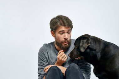 Evcil hayvan sahibi siyah köpek eğitim modeli duyguları olan mutlu bir sahip.