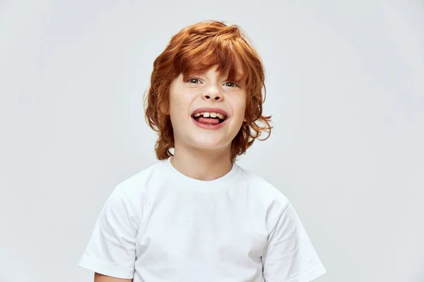 Rödhårig pojke som visar tungan ansikte närbild beskärd vy vit t-shirt — Stockfoto