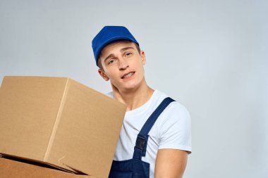 Elinde kutular olan üniformalı bir işçi. Yükleyici yaşam tarzı.