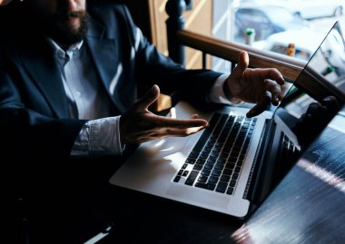 İş adamı dizüstü bilgisayarın önünde kitap işi iletişim teknolojisiyle bekliyor.