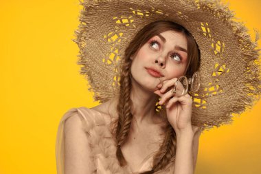 Şapkalı ve elbiseli bir bayan. Kızıl saçlı, sarı arka planlı, model portresi eğlenceli.