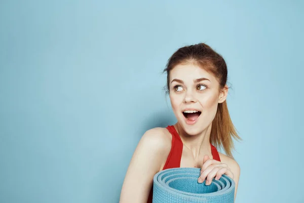 Sportive woman in red tank top mat for workout exercises lifestyle blue background — Stock Photo, Image