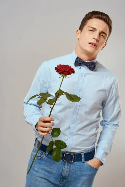Handsome man with red rose blue shirt bow tie light background cropped view — Stock Photo, Image
