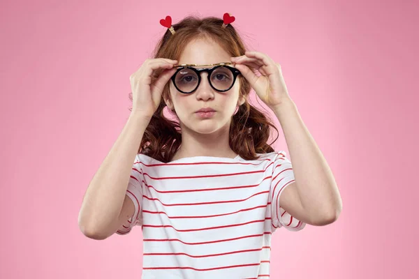 Schattig meisje zonnebril gestreept t-shirt lifestyle leuk stijl roze achtergrond — Stockfoto