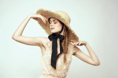 Şapkalı ve arka planda giyinmiş romantik bir kadın elleriyle komik duyguların portresini çiziyor.