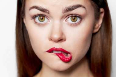 Güzel bir kadın yüzü kırmızı dudaklarını ısırıyor. 