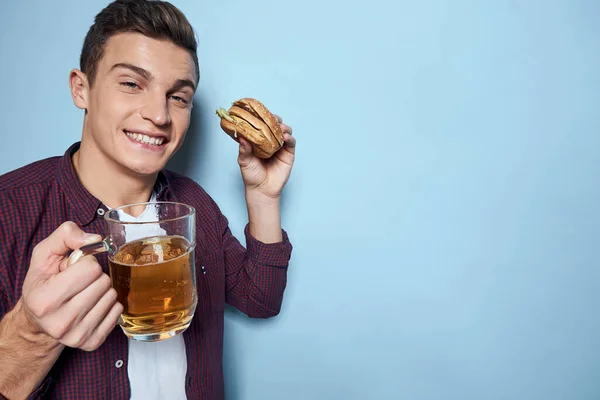 Vrolijk dronken man met bier mok en hamburger in de hand dieet voedsel levensstijl blauwe achtergrond — Stockfoto