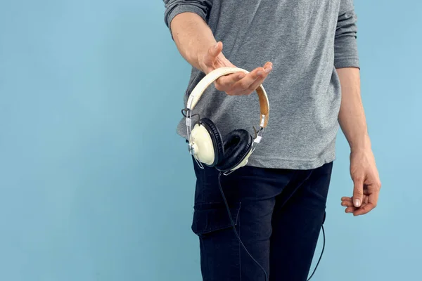 Άντρας κρατώντας ακουστικά στα χέρια του μουσική lifestyle τεχνολογία μπλε φόντο — Φωτογραφία Αρχείου