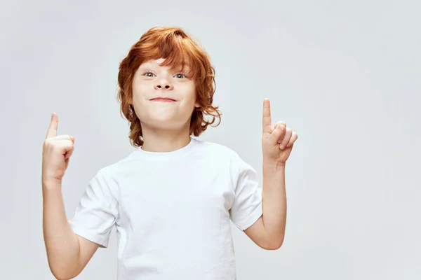 Roodharige jongen gebaar met twee handen tonen opwaartse glimlach wit t-shirt Copy Space. — Stockfoto