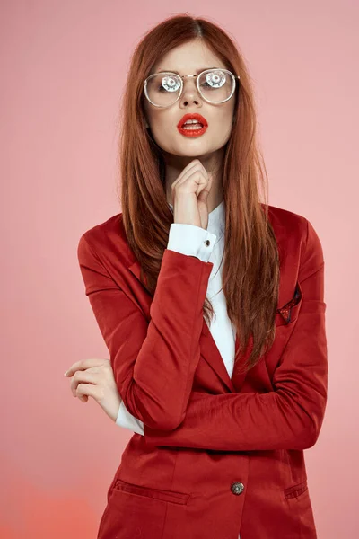 Mujer bonita chaqueta roja gafas elegante estilo rosa fondo — Foto de Stock