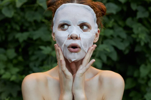 얼굴에 마스크를 쓴 여자의 모습은 손으로 피부를 깨 끗이 씻은 얼굴을 만진다 — 스톡 사진