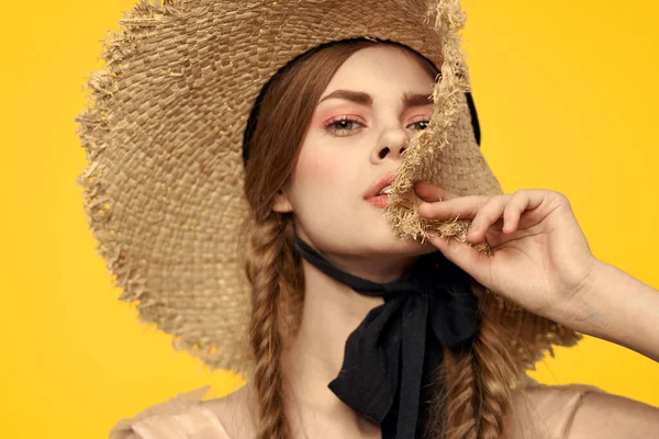 Sarı arka planda saman şapkalı portre kadın. Yazlık elbise mankeni romantizmi.