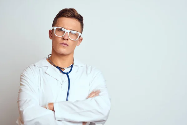 Medico in abito medico con stetoscopio e occhiali su sfondo chiaro ritagliato vista ritratto — Foto Stock
