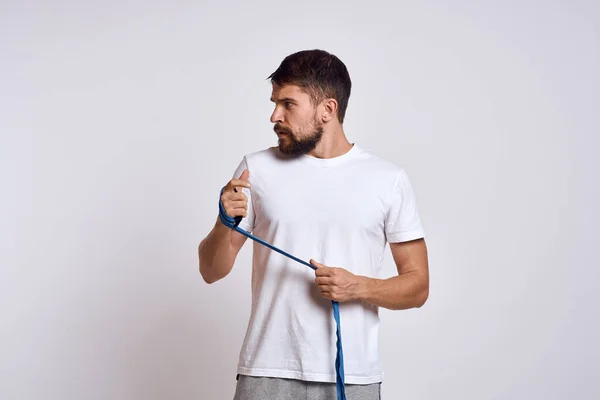 Homem de esportes em branco t-shirt azul bandagens de boxe em seus exercícios de treino de braços — Fotografia de Stock