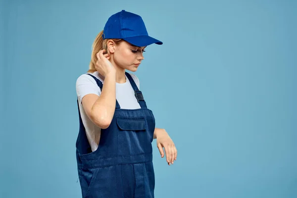 Woman in work uniform blue cap carriage delivery service courier blue background