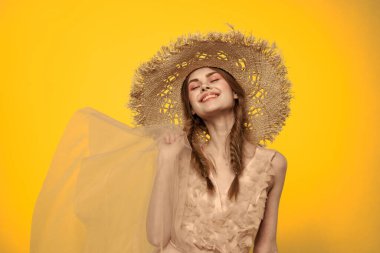 Sarı arkaplan duygularıyla elinde hasır şapkalı bir kadın... 