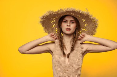 Şapkalı ve elbiseli bir bayan. Kızıl saçlı, sarı arka planlı, model portresi eğlenceli.