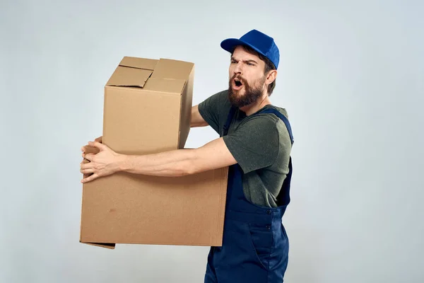 Homem em uniforme de trabalho com caixas em mãos entrega carregamento estilo de vida — Fotografia de Stock