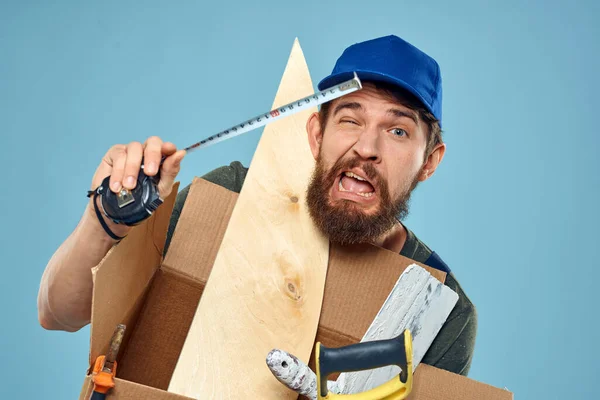 Trabajador hombre en uniforme caja herramientas construcción fondo azul — Foto de Stock