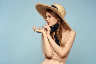 Gri arka planda hasır şapkalı romantik bir kız ve bej renkli bir elbise siyah kurdele duygu modeli.