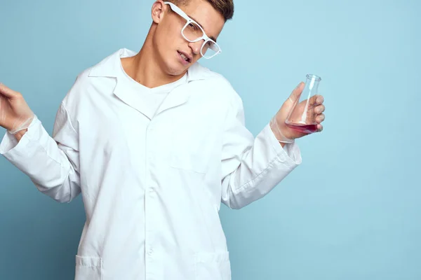 Człowiek trzymający kolby kolorowy płynny chemiczny model laboratoryjny noszący okulary — Zdjęcie stockowe