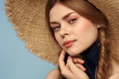 Hasır şapkalı kız portresi yakın çekim at kuyruğu eğlenceli kızıl saçlı mavi arka plan