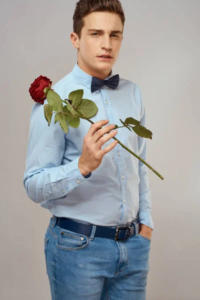 英俊男子，红玫瑰蓝衫领结浅色背景剪影 — 图库照片