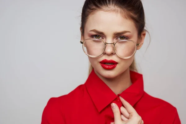 Modische Frau in einem roten Hemd auf hellem Hintergrund Spaß Emotionen helle Make-up-Brille attraktives Aussehen — Stockfoto