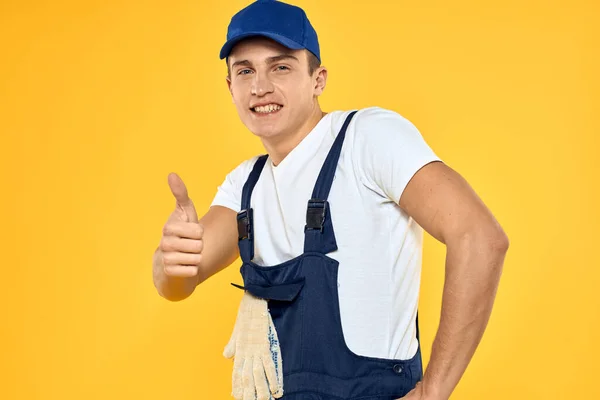 Man in het werken uniforme emoties rendering service delivery service gele achtergrond — Stockfoto