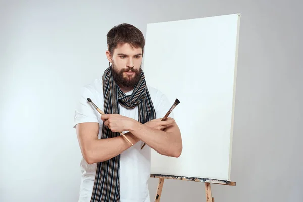 이젤 (easel) 미술 취미의 가벼운 배경 스카프를 목에 두르고 있는 남성 미술가 — 스톡 사진