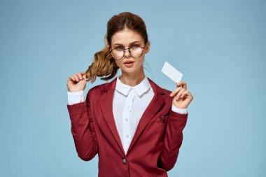 İş kadını kırmızı ceketli, gözlüklü, yönetici mavi arka planlı.