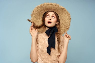 Gri arka planda hasır şapkalı romantik bir kız ve bej renkli bir elbise siyah kurdele duygu modeli.