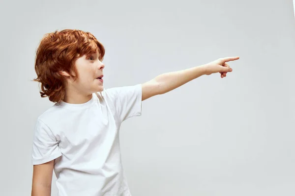 Emocjonalny rudowłosy chłopiec pokazuje palec do bocznego widoku — Zdjęcie stockowe