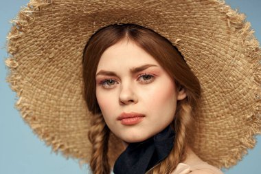 Hasır şapkalı kız portresi yakın çekim at kuyruğu eğlenceli kızıl saçlı mavi arka plan