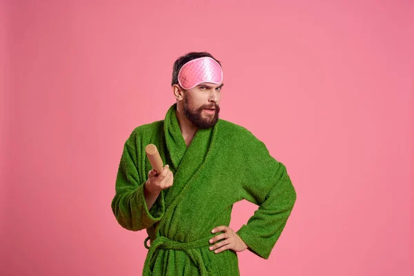 Портрет человека в розовой маске для сна и модель раздражительности зеленого халата — стоковое фото