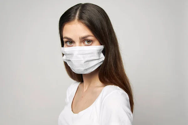 Flicka i en medicinsk mask vit t-shirt långt hår närbild — Stockfoto