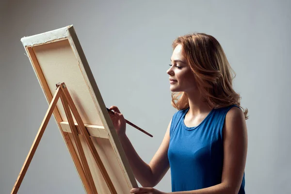 Vrouw kunstenaar met penseel verf op ezel kunst hobby licht achtergrond — Stockfoto