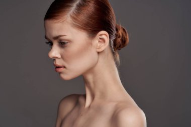 Güzel bir kadın çıplak omuzlar kozmetik temiz cilt cazibesi gri arka plan stüdyosu